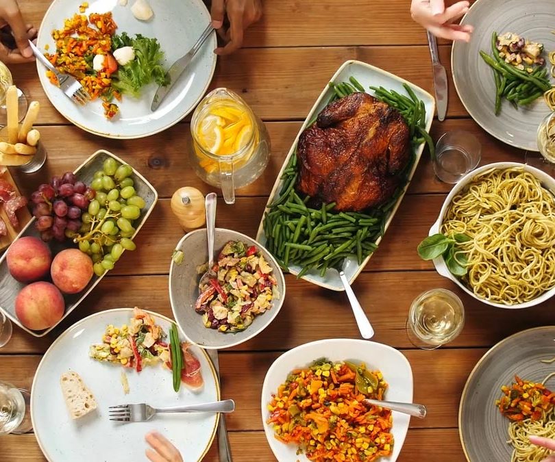 Table en bois recouverte de plats et de nourriture