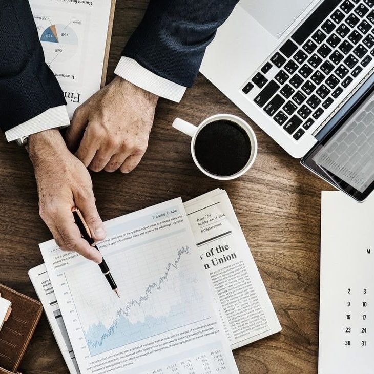 Homme en costume qui montre un graphique sur une feuille