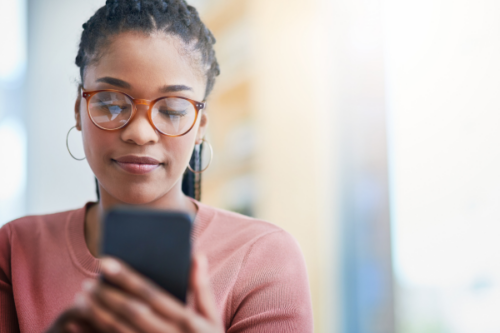 Fille en train de poster une publication sur les réseaux sociaux avec son téléphone