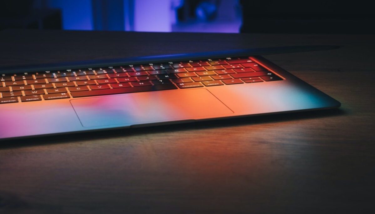 POUSH-ordinateur-apple Ordinateur ouvert sur un bureau avec le reflet des couleurs du storytelling affiché sur l'écran