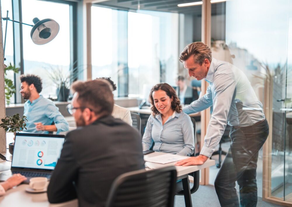 un homme et une femme au milieu d'une équipe qui travaille dans une agence marketing