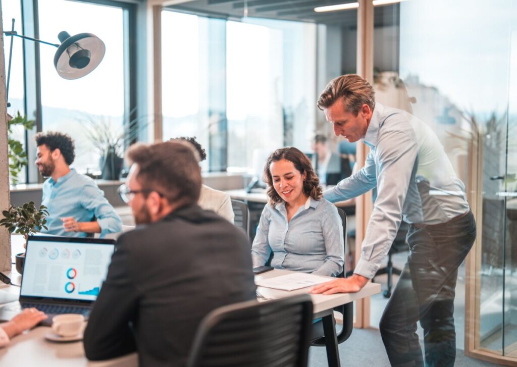 un homme et une femme au milieu d'une équipe qui travaille dans une agence marketing