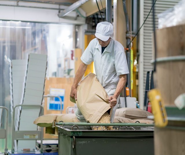 ganesh-metiers-alimentaire Un employé qui verse des grains dans un bac pour représenter le métier alimentaire