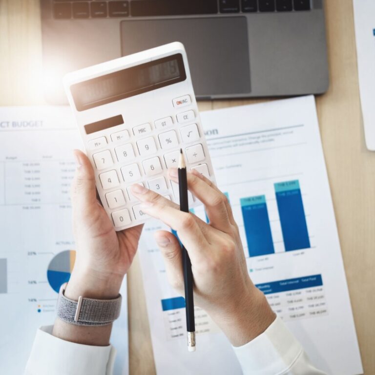 Mains qui tiennent une calculette avec des feuilles à l'arrière