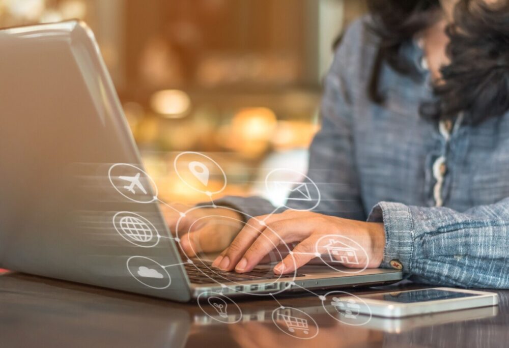 femme qui tape au clavier de son ordinateur avec des logos web