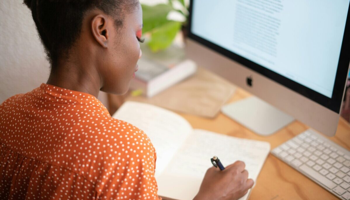 femme copywriter Femme copywriter devant un écran d'ordinateur qui écrit sur un carnet de notes