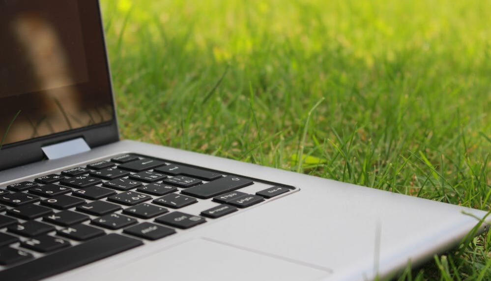 Ordinateur portable posé dans l'herbe