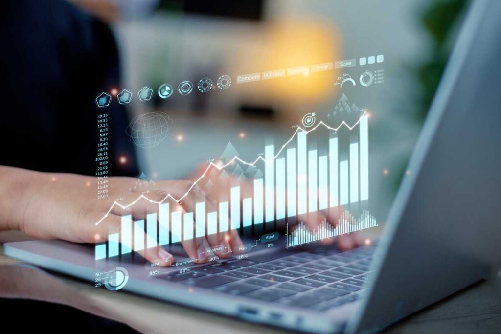 Une personne analyse des données sur un ordinateur portable, affichant des graphiques interactifs en 3D et des icônes de gestion.