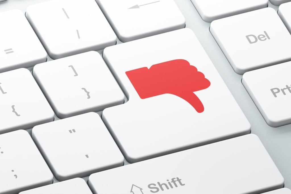 Clavier d'ordinateur avec une touche avec un pouce rouge tourné vers le bas